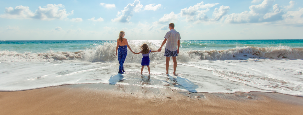 A photo of a mother, daughter, and father at the sea