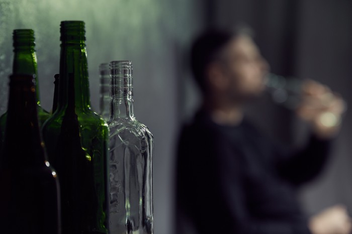 a photo of a man and bottles of alcohol