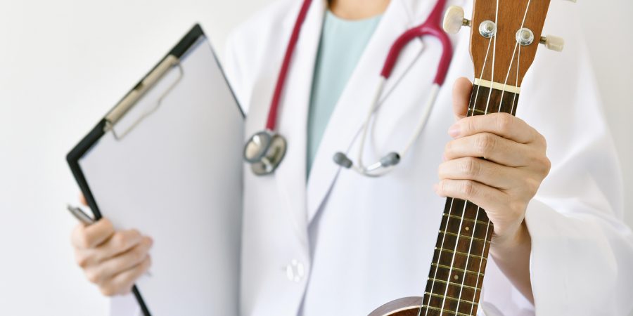 CLose-up of doctor holding a clipboard and guitar