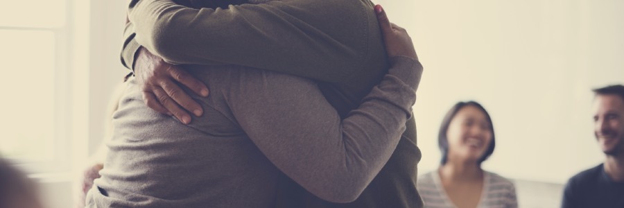 two people hugging during a group therapy session